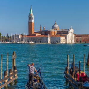 vertical shot of a man on a boat and the st mark's square on the background