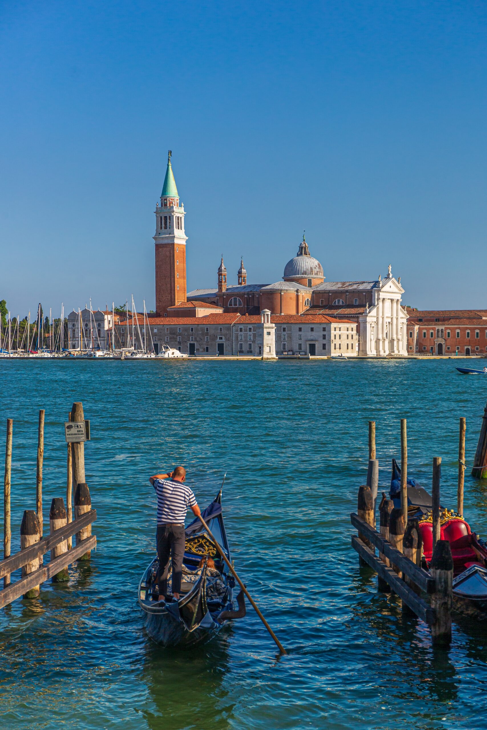 vertical shot of a man on a boat and the st mark's square on the background